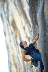 Rock climber climbing up a cliff