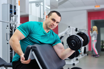 Fototapeta na wymiar Exercises for the biceps with dumbbells