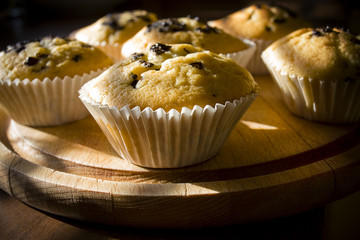 Sweet muffins on a wooden board in daylight