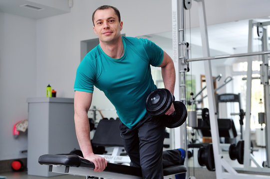 Image of fitness guy in gym exercising with dumbbells