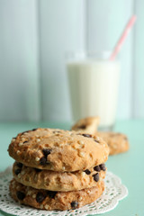 Tasty cookies and glass of milk on color wooden background