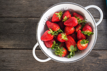 Sweet ripe strawberries in rustic colander