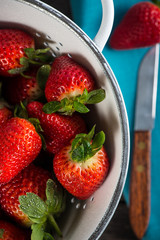 Fresh just clean wet strawberries in rustic colander