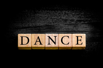 Word DANCE isolated on black background with copy space