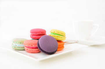 Macaroons on white plate and coffee cup