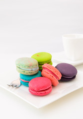 Macaroons on white plate and coffee cup