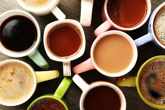 Fototapeta Many cups of coffee on wooden table, top view