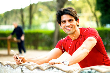 Naklejka premium Runner smiling and holding a mobile phone in hand