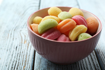 Sweet candies on color wooden table, closeup