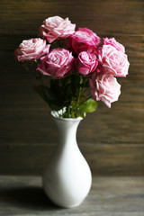 Bouquet of beautiful fresh roses on wooden background
