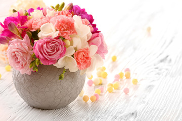 Beautiful fresh spring flowers in pot on wooden table, closeup