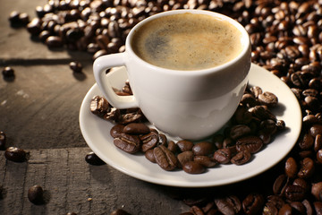 Cup of coffee with grains, closeup