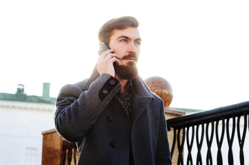 stylish man with a beard talking on cell phone