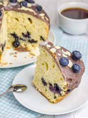 Piece of homemade blueberry cake with icing and berry on top