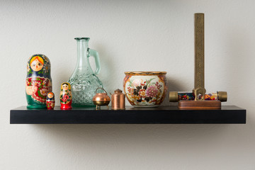 Wall shelf with pottery, kaleidoscope and dolls