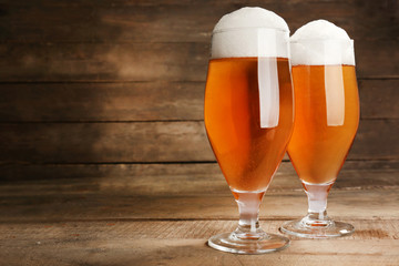 Glasses of beer on wooden background