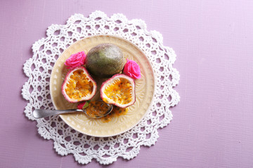 Passion fruit on plate on color wooden background