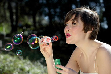 Woman blows soap bubbles