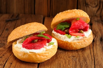 Two sandwiches with cured salmon, cream cheese, parsley, capers