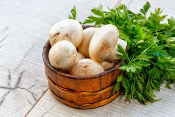 Fresh mushrooms champignon in wooden bowl