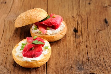 Two sandwiches with cured salmon, cream cheese, parsley, capers