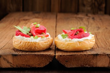 Two sandwiches with cured salmon, cream cheese, parsley, capers