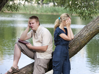 guy and the girl in quarrel on the bank of the lake