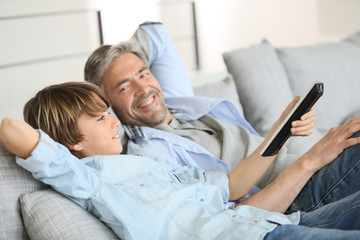 Obraz premium Father and son watching tv together