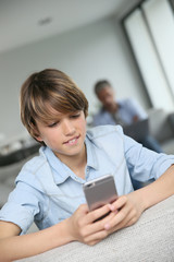 Fototapeta na wymiar Teenage boy using smartphone at home