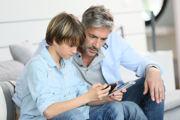 Father and son playing with smartphone
