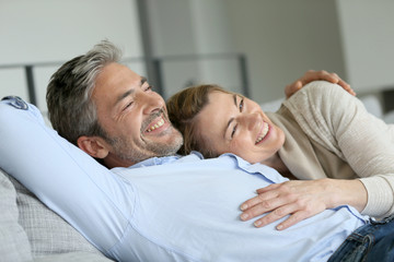 Mature couple relaxing in sofa, peaceful scene - Powered by Adobe