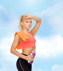 tired sporty woman with towel and water bottle