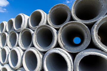 Concrete drainage pipes stacked at construction site background
