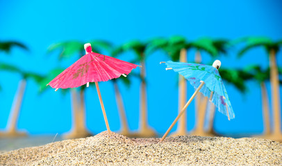 two small umbrellas on a beach