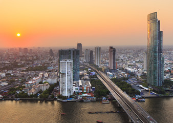 Fototapeta na wymiar River in Bangkok city with high office building at sunset