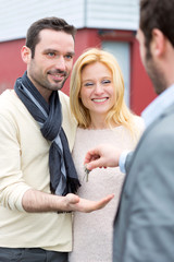 Real estate agent delivers keys to young atractive couple