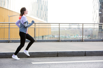 Obraz na płótnie Canvas Young attractive woman running downtown