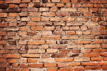 Old empty brick wall background, plaster falling off.