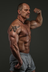 Fototapeta na wymiar Muscular middle age man showing his muscules