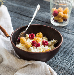 cottage cheese with raspberries in a dark clay plate, cinnamon s