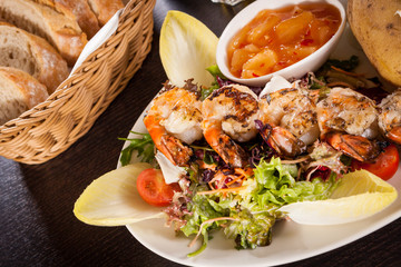 Grilled prawns with endive salad and jacket potato