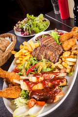 Platter of mixed meats, salad and French fries