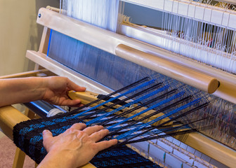 Woman Weaving a Wool Scarf on a Floor Loom