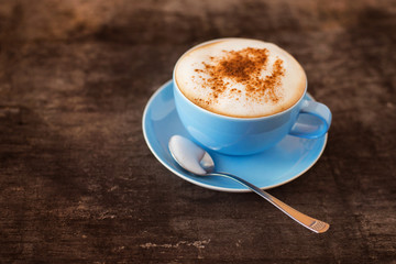 Cup of coffee on a wooden table background