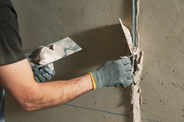 Woker fixes a guide to align the walls with stucco