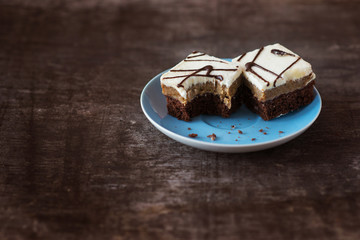 Piece of cake on a plate on wooden table background.