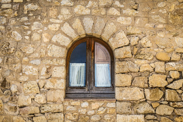 Fototapeta na wymiar Old closed wooden window on a stone wall