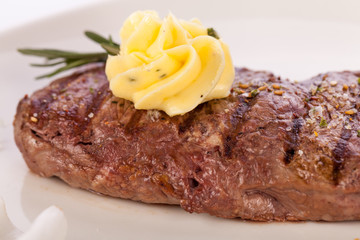 Grilled beef steak topped with butter and rosemary