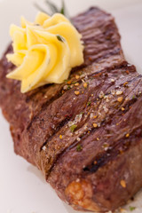 Grilled beef steak topped with butter and rosemary