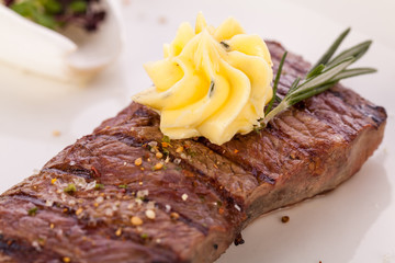 Grilled beef steak topped with butter and rosemary